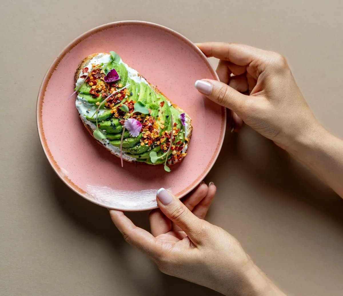 Avocado toast at Tessori — fanned avocado on sourdough with chilli flakes, sesame, microgreens and edible flowers