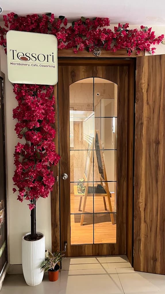 The Tessori entrance on the second floor, with the sign and bougainvillea over the wooden door